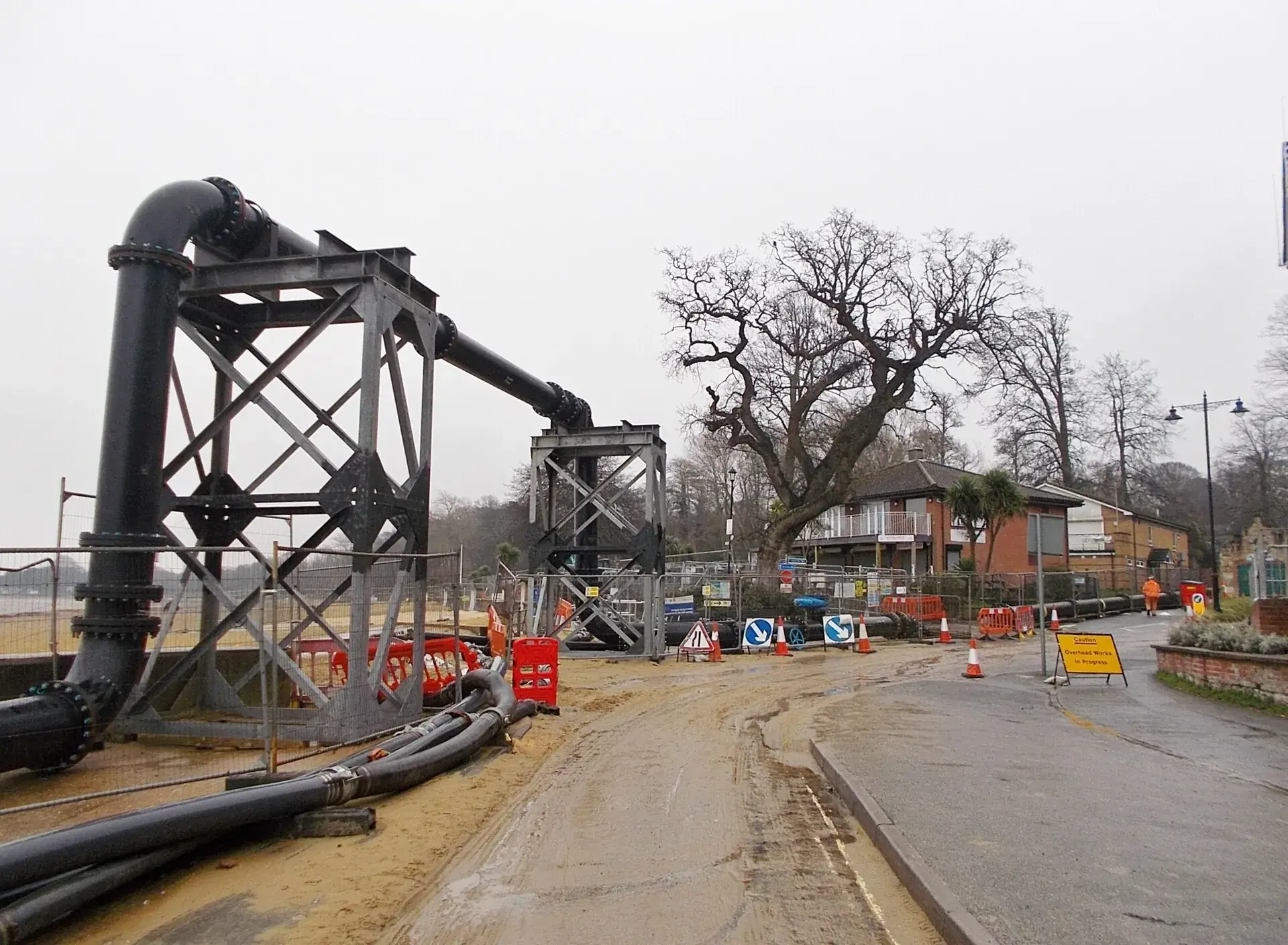 A street excavated for sewer repairs, with pipe machinery in place